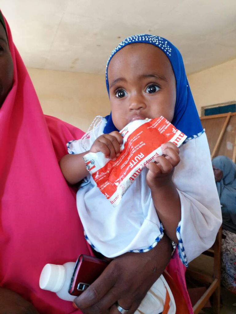 young girl eats nutripacket in Somalia